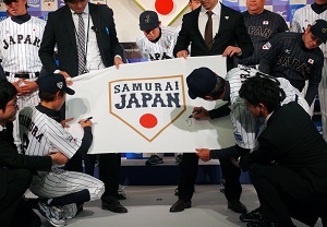 フラッグにサインする大倉監督（右）と志村選手（左）。このあと監督と代表選手全員がサインした