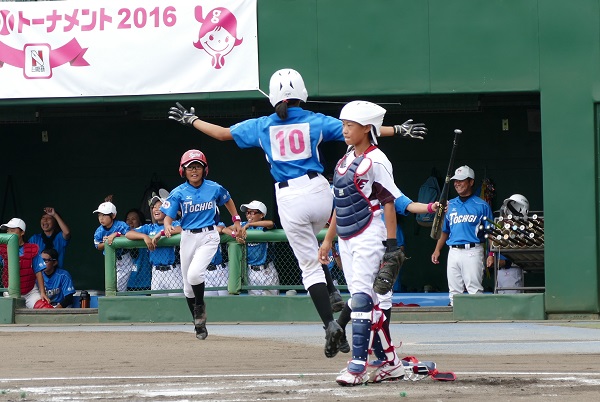 2回裏、両手を広げ、ジャンプしながらホームを踏む栃木の三浦選手