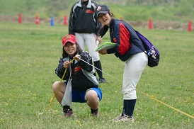 計測する東京女子体育大学の選手と、日本女子体育大学の記録係（矢川グラウンド）